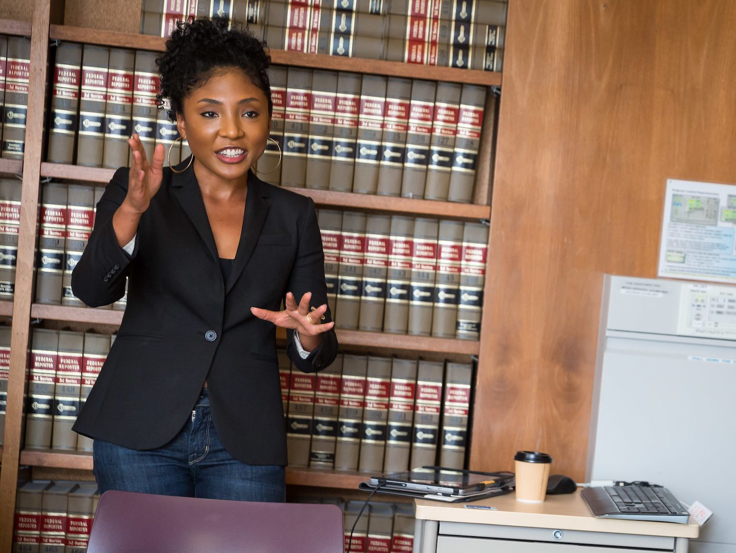 UC Law SF student giving a presentation in front of a wall of books