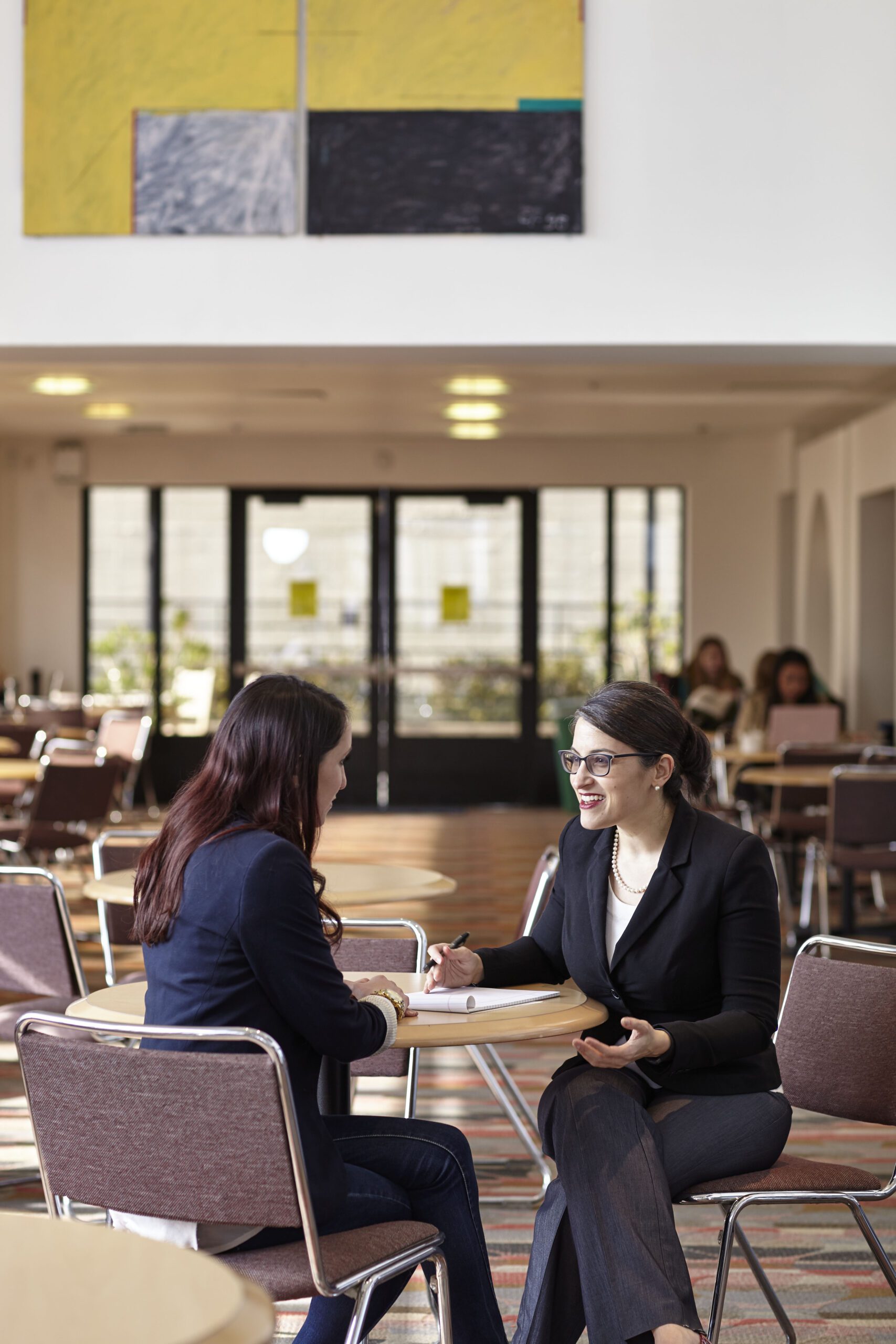 UC Law SF dining hall with faculty and student speaking