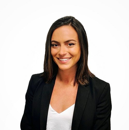 Woman smiling at the camera, wearing a white top and black suit jacket