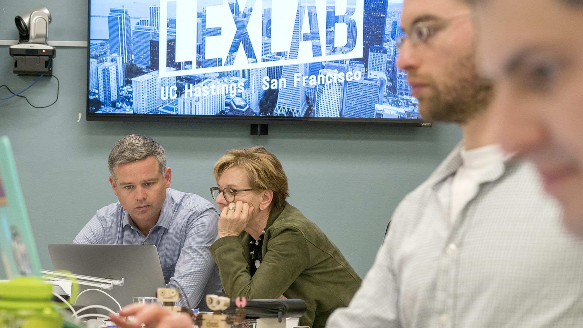 Two people in foreground and Drew Amerson and Alice Armitage in the background.