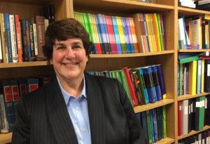 Photo of Laurie Zimet with bookshelves in the background.