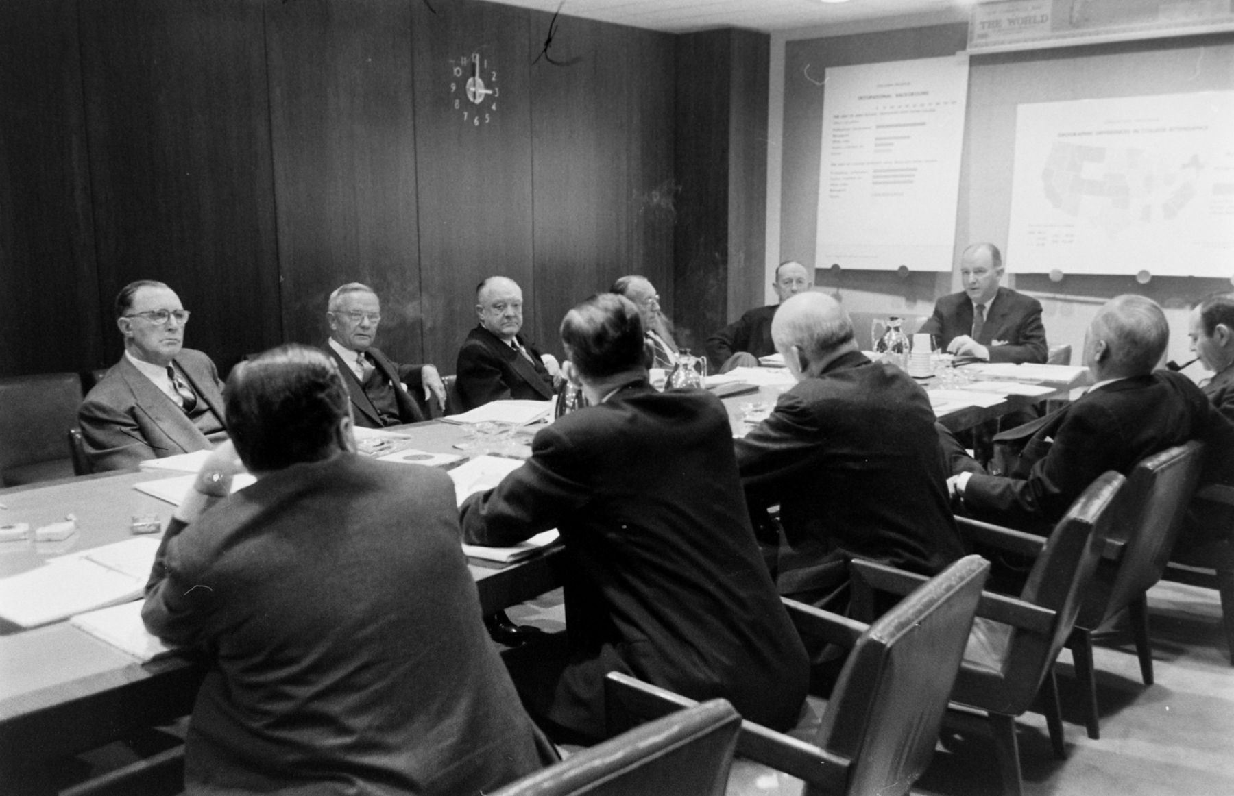 Black and white photo of group of white men in boardroom