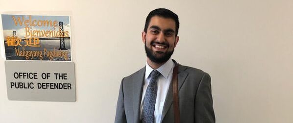 Student smiling outside his workplace