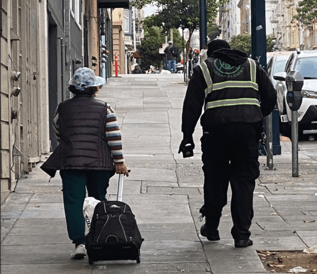 Urban Alchemy Practitioner escorting someone along the sidewalk