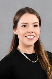 smiling professional Latina woman in black shirt with gold necklace