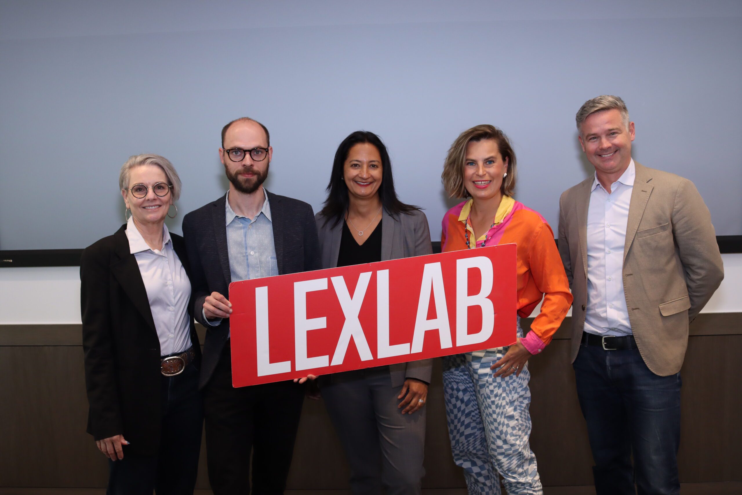 Professors and legal technology entrepreneuers pose with a UC Law SF LexLab sign
