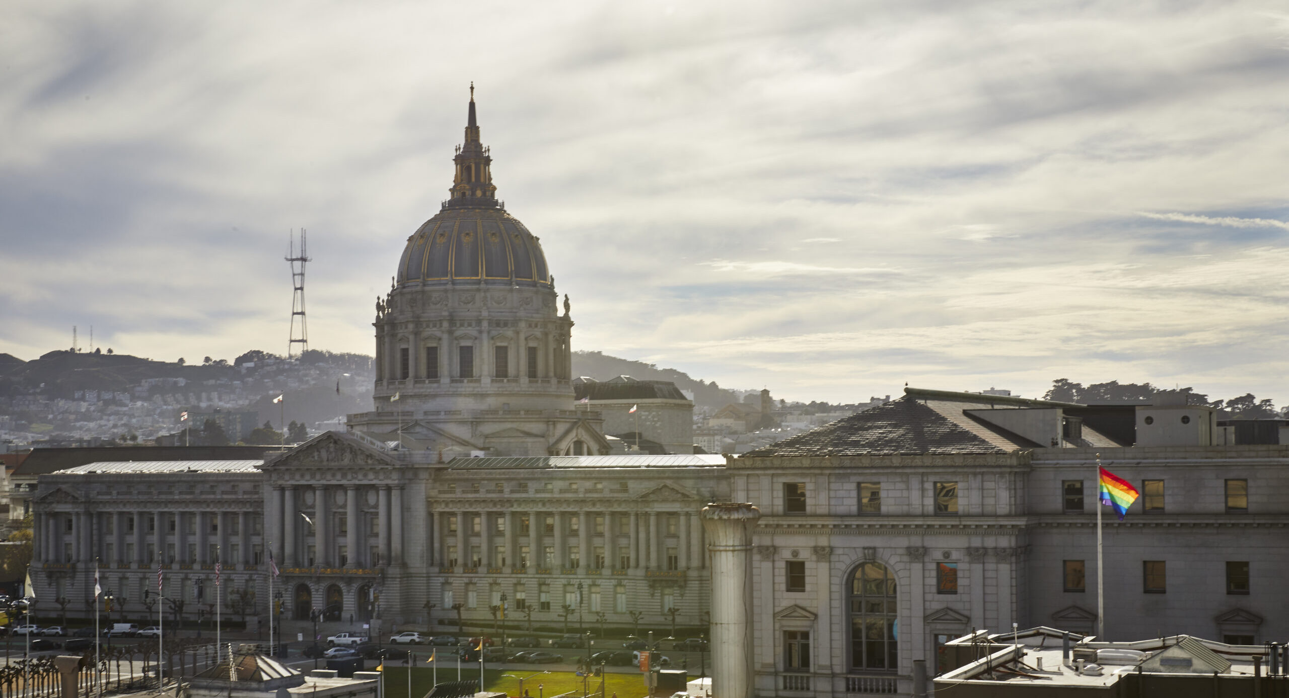 Aerial shot of dome building, SF city hall. Cloudy skies, sun shining in the backdrop