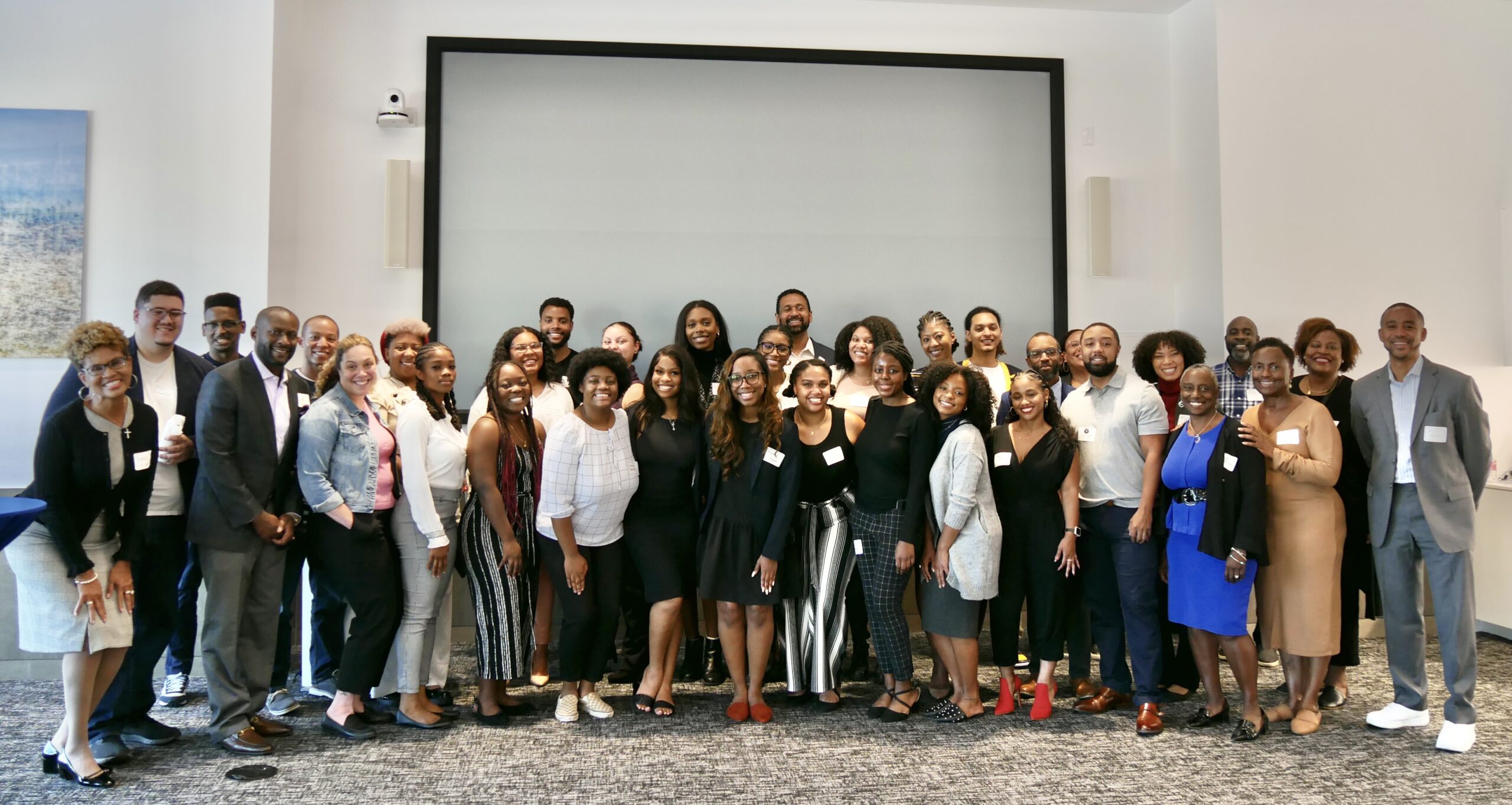 A large group of people, including alumni and professors, are posing together at a scholarship fund launch event for the Black Law Students Association.