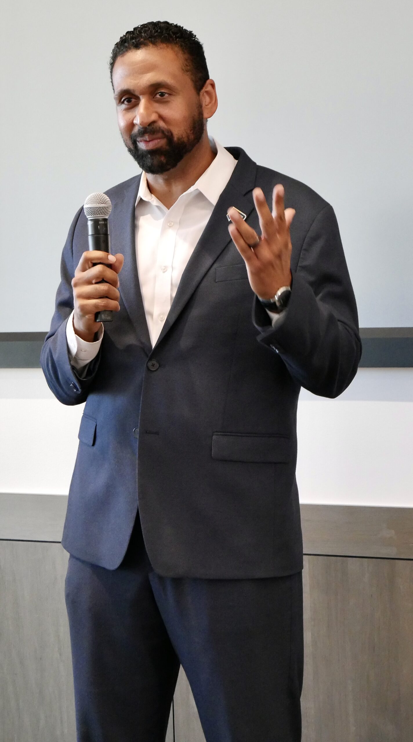 Andrew Houston, a member of the UC Law SF Board of Directors, speaks at a scholarship fund launch event, holding a microphone and gesturing.