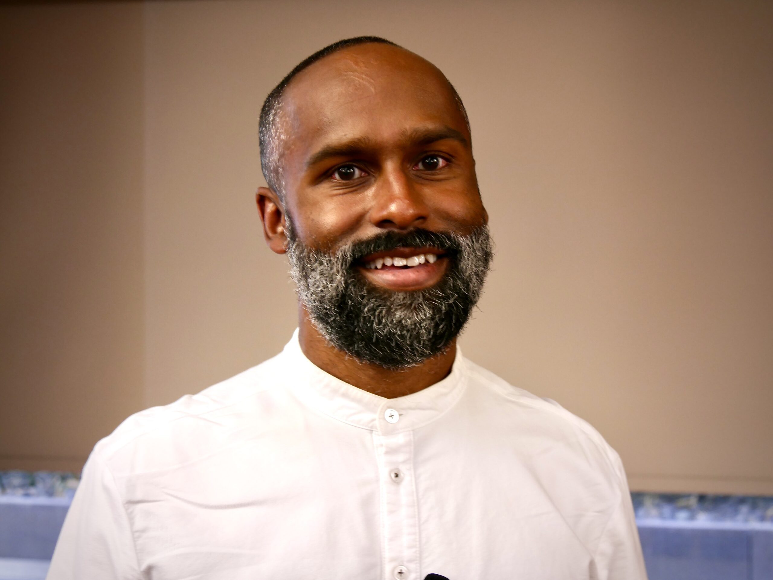 ACLU attorney Emerson Sykes smiles while standing in front of a podium, discussing free speech, academic freedom, and racial justice at UC Law SF.