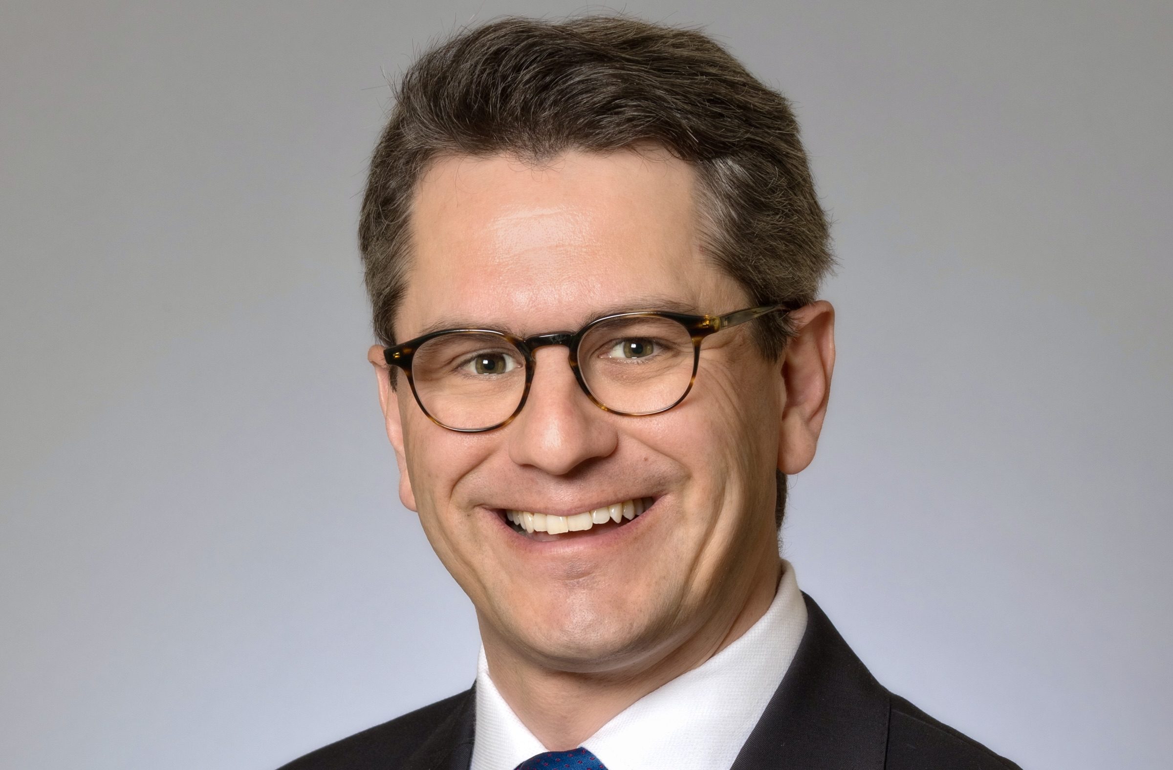 law professor wearing suit, tie, glasses