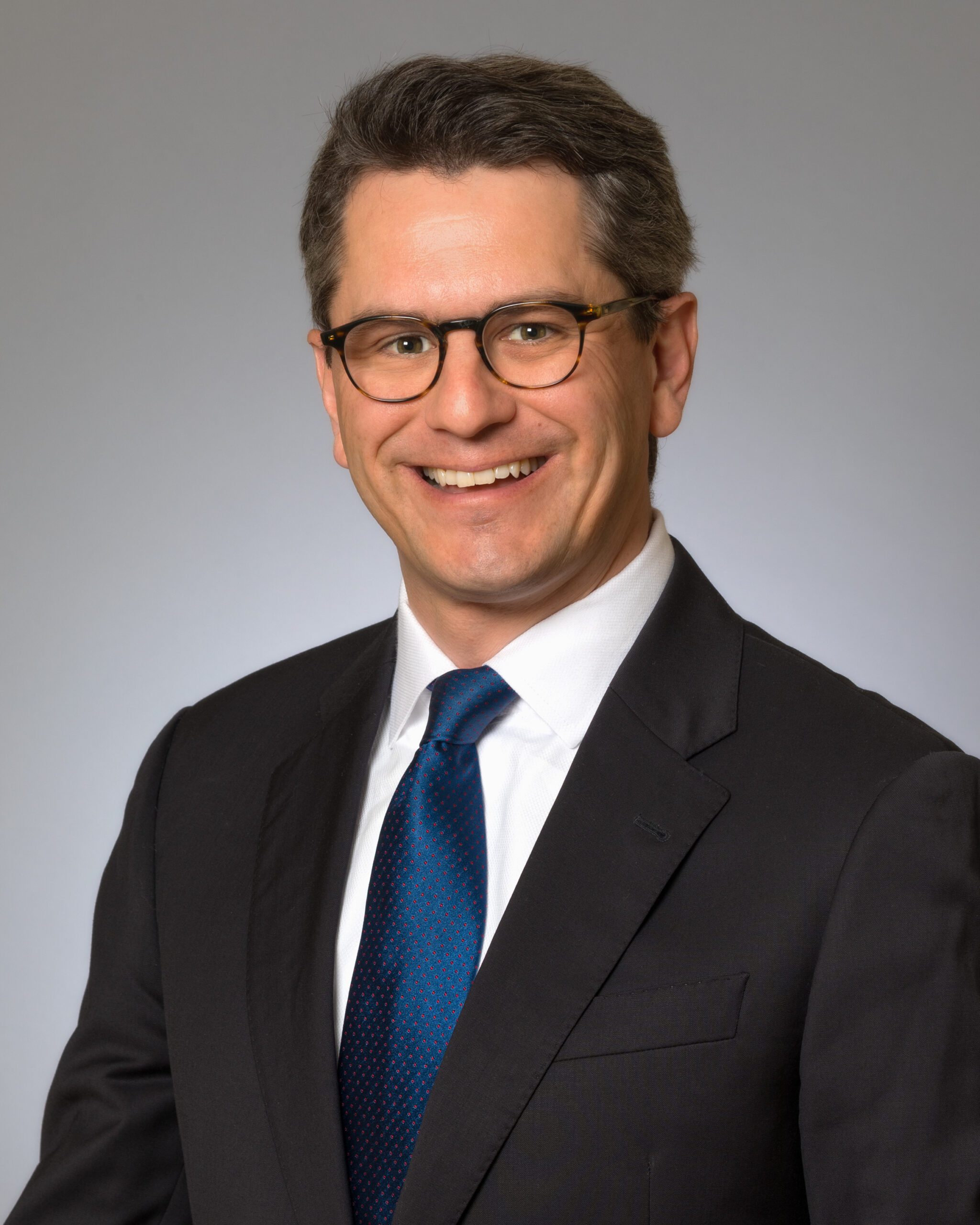 man wearing suit, tie and glasses