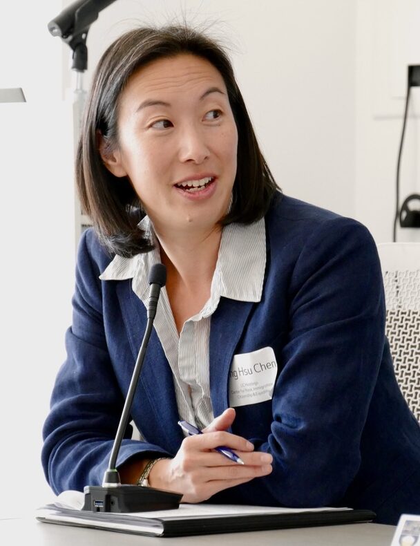 professional woman wearing blue suit talks during panel discussion