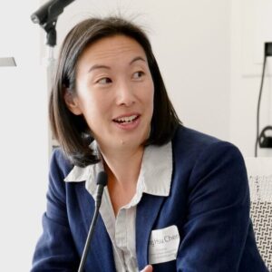 professional woman wearing blue suit talks during panel discussion