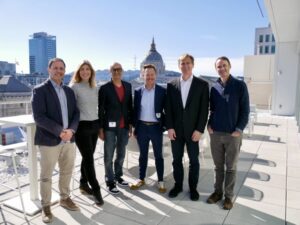 Four experts posed with CBL Executive Director before a panel talk on equity compensation for unicorn startups, with a city skyline in the background.