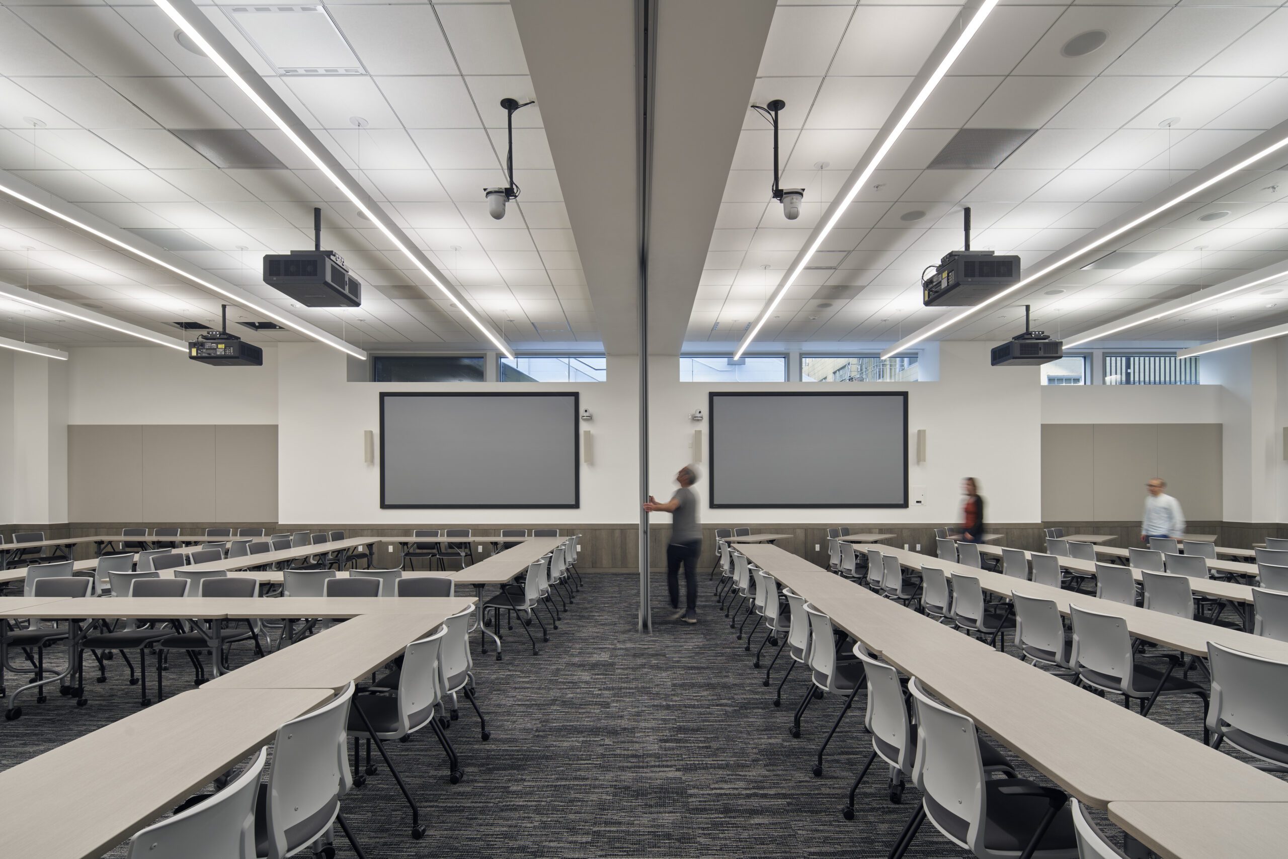 Technicians removing a divder in large conference space.