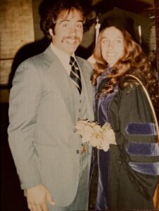 Roger Dreyer in a suit and Carol Wieckowsk Dreyer in graduation regalia