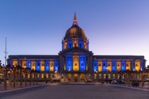 SF City hall building lit up in blue and gold