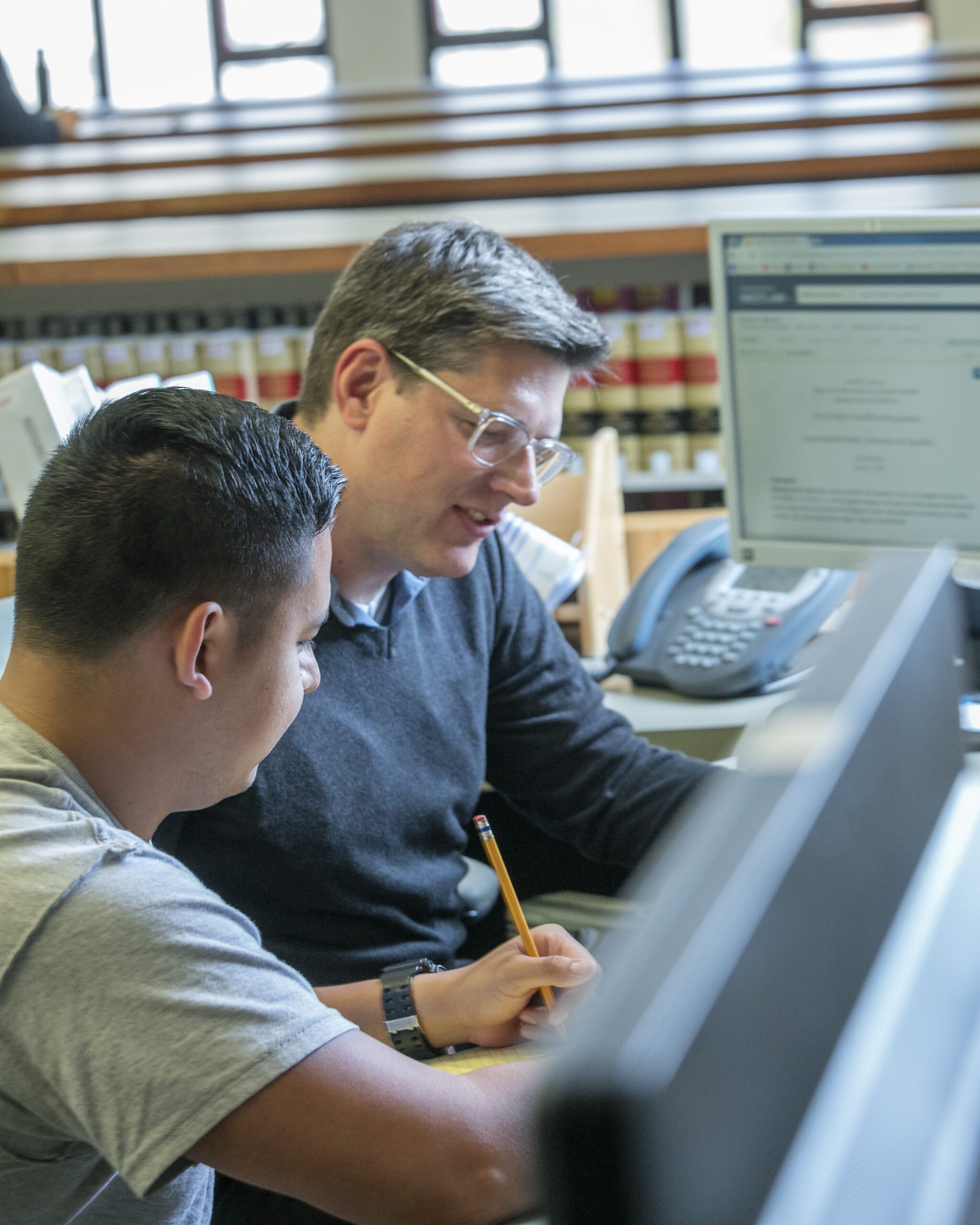 A librarian helping a student at the reference desk