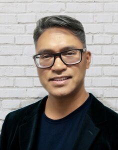 A headshot photo of Eugene Dumlao