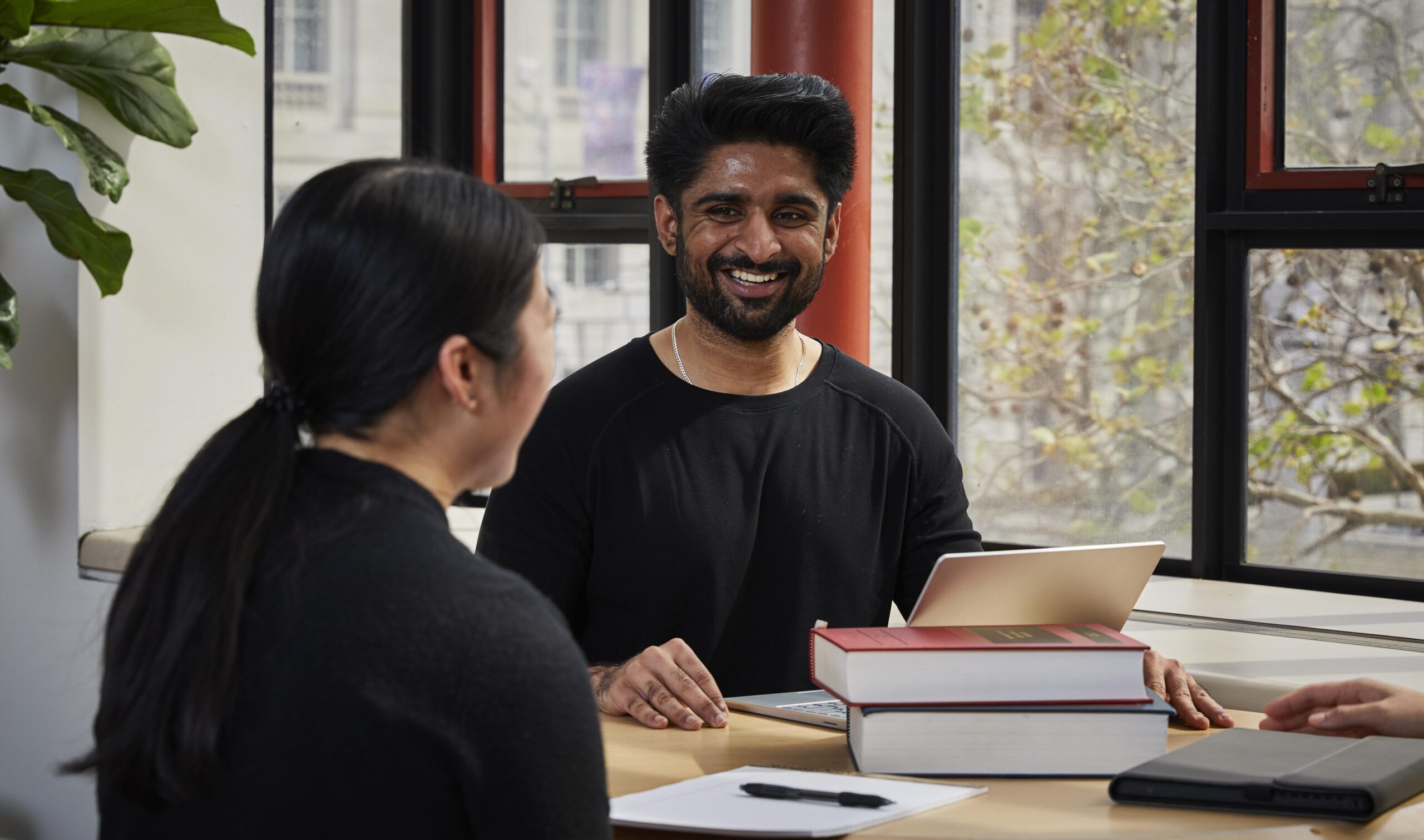 students talking while studying at a table in the dining commons