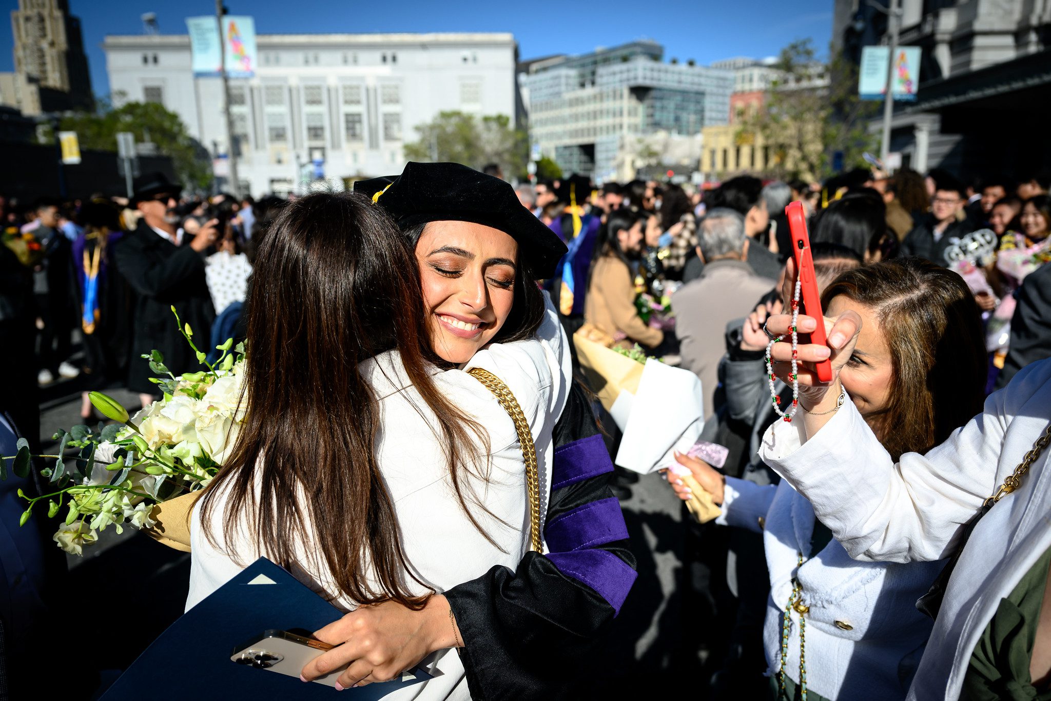 A graduate hugging someone right after the commencement ceremony.