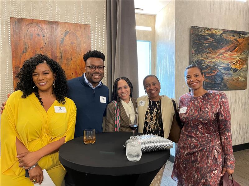 Alumni gathered around a table at a social event.