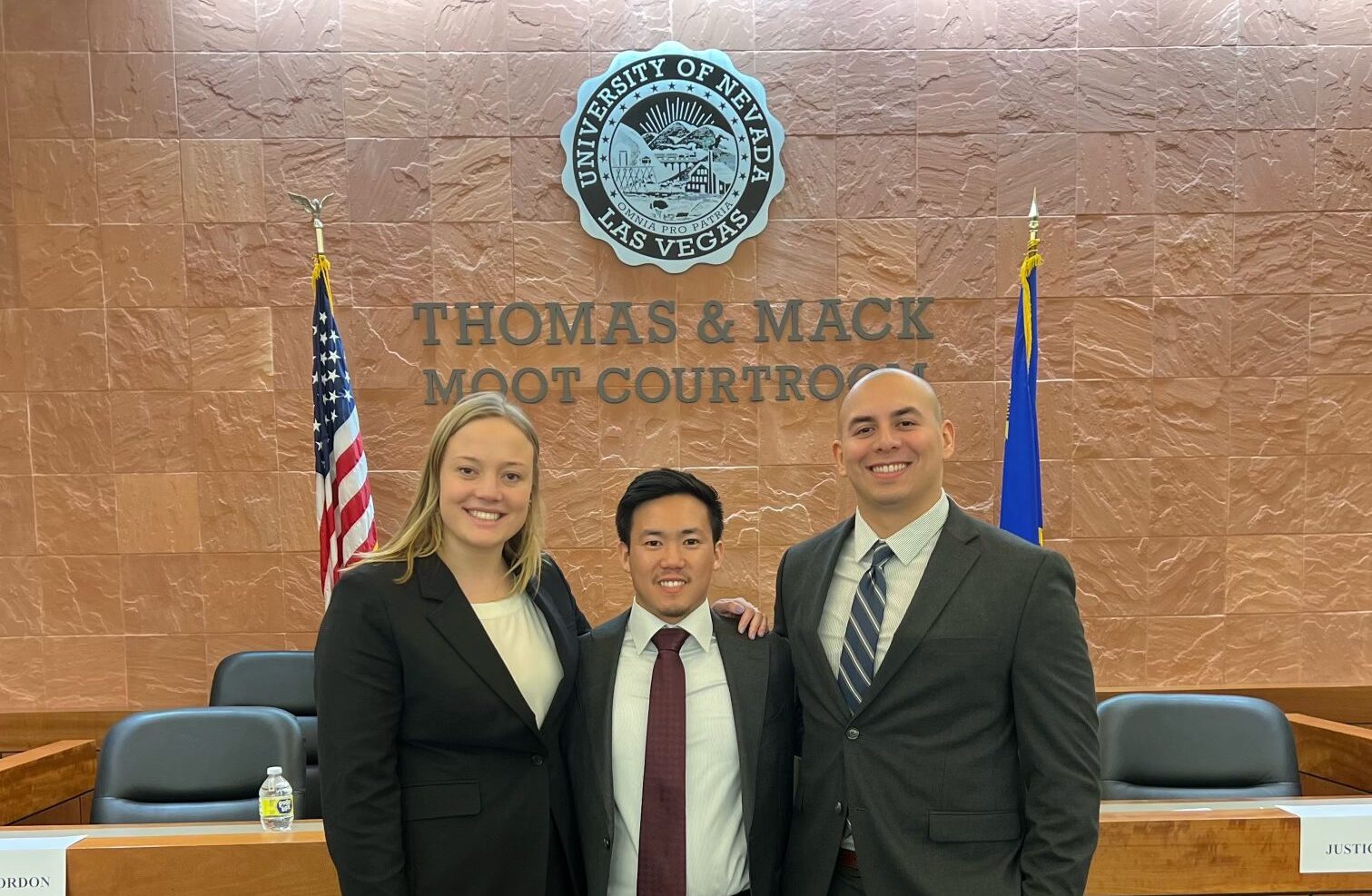 moot court team standing in front of thomas & mace moot courtroon