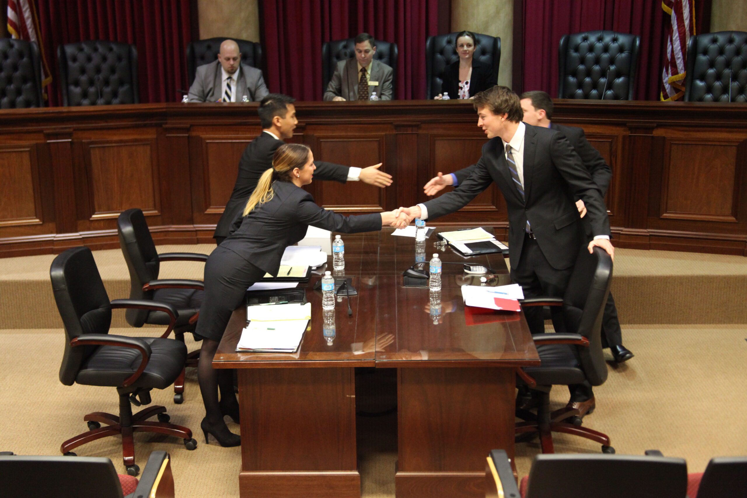 two trial teams, shaking hands across the table after a match