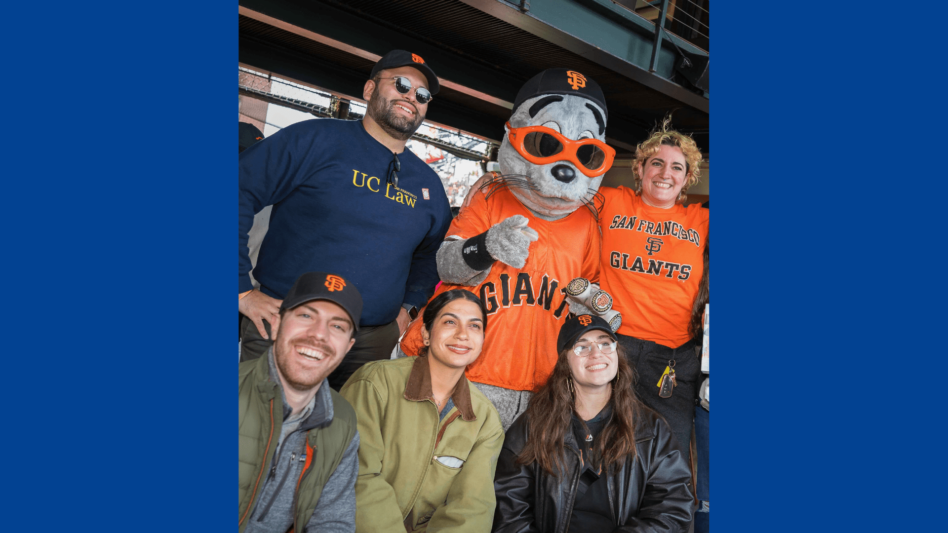 UC Law SF alumni pose with San Francisco Giants mascot Lou Seal at Oracle Park during a Spring Week game event organized by the Alumni Association.