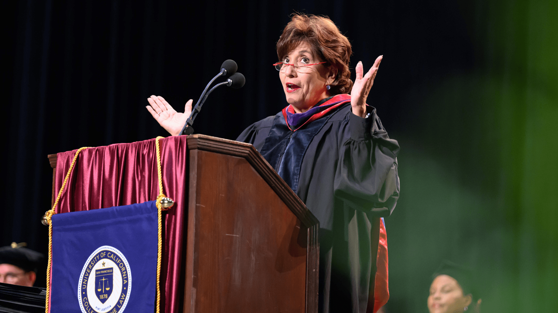 Chief Judge Mary H. Murguia of the U.S. Court of Appeals for the Ninth Circuit giving the keynote address at commencement. She's standing behind a podium on stage at the Bill Graham Civic Auditorium.