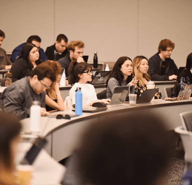 Students in a UC Law SF lecture theatre with laptops open in front of them.