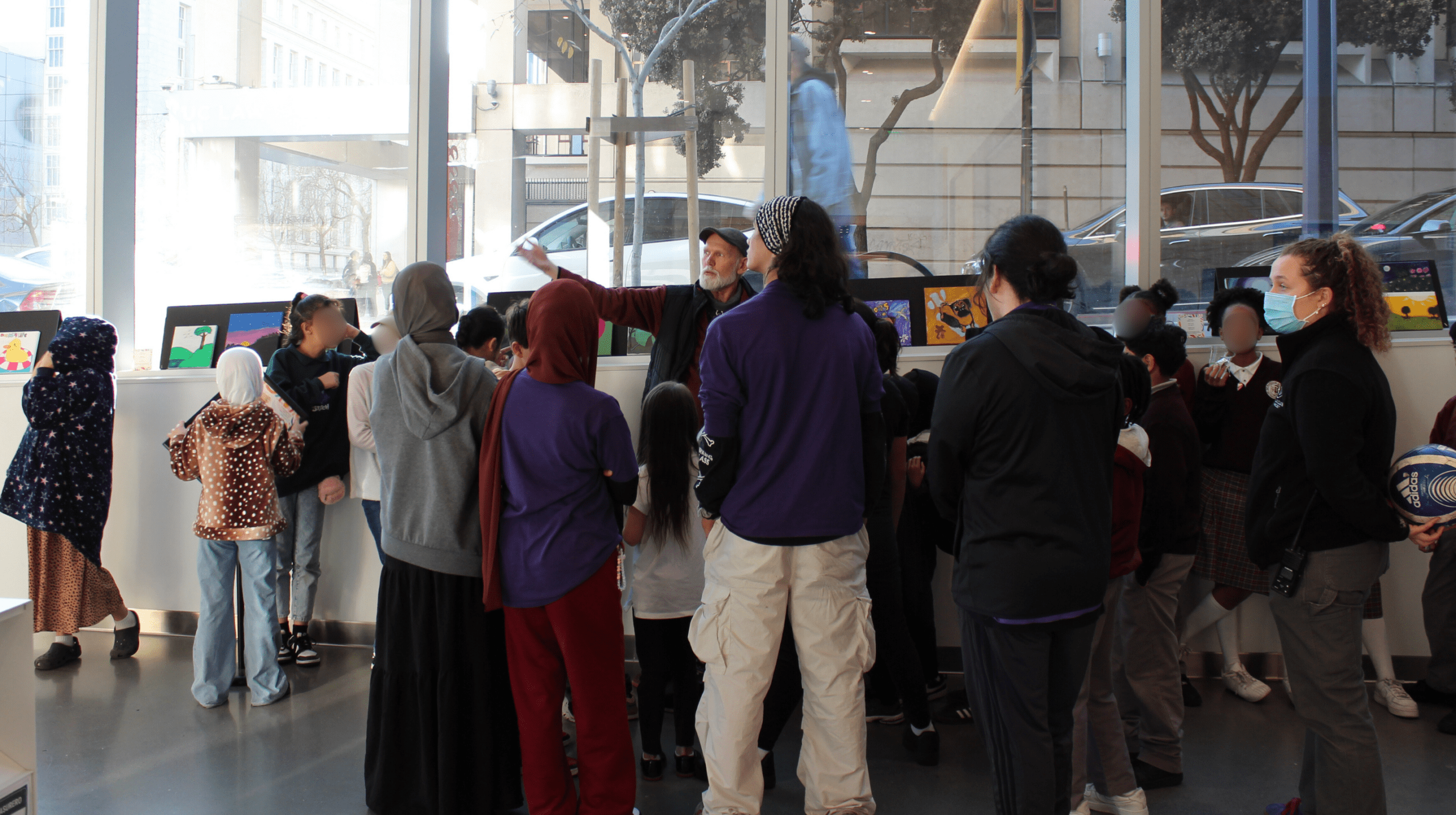 A group of people gather for an art show.