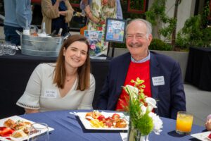 Chief Advancement Officer Julia Jordan and alum Thomas Macbride, who graduated in 1975, seated at a table.