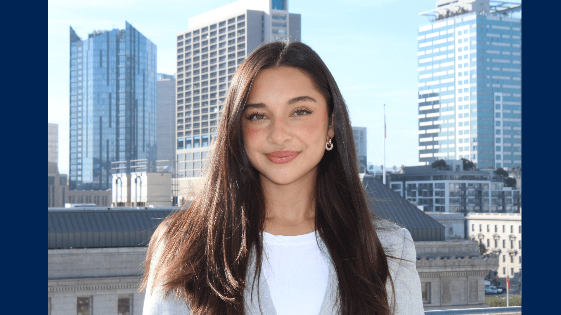 Headshot photo of law student Renee Applegate standing in front of a skyline in business attire.