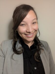 A photo of Mayeli Soto wearing a grey blazer and smiling.