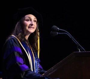 Valedictorian Judy Shamshikh ’25 speaks into a microphone