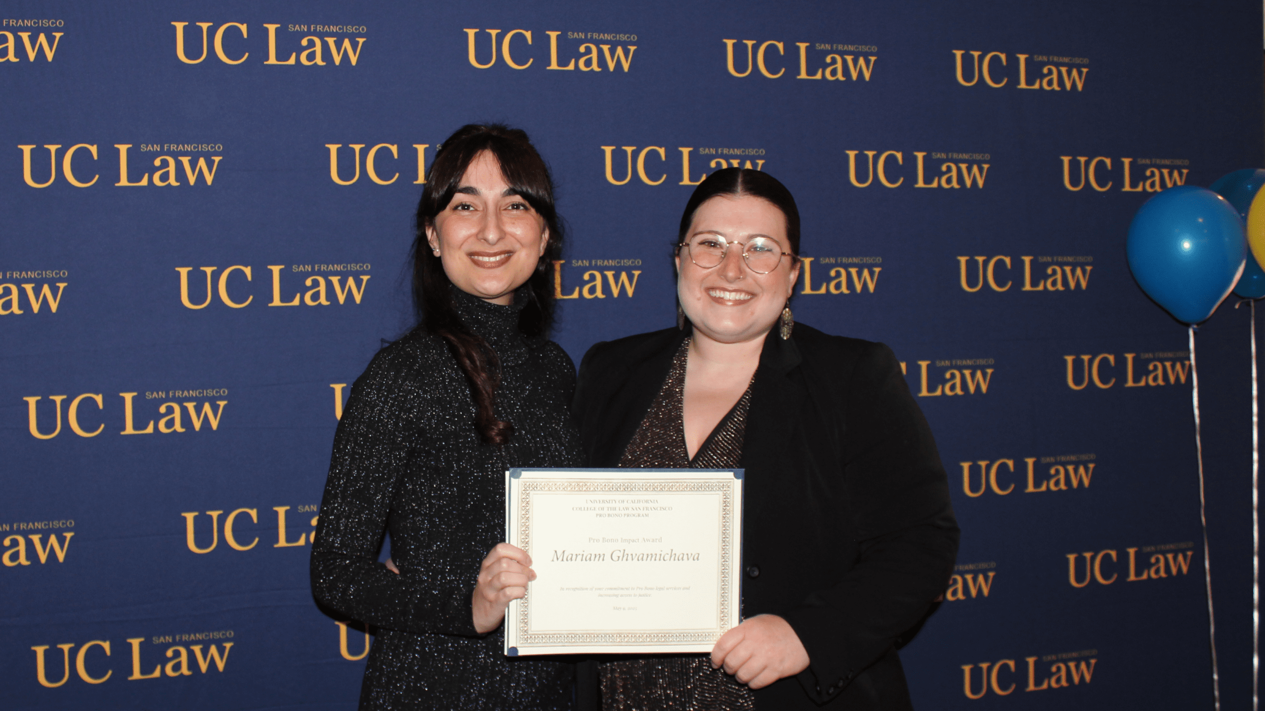 Graduate Mariam Ghvamichava with Simone Levine. They are holding Marium's Pro Bono Impact Award between them
