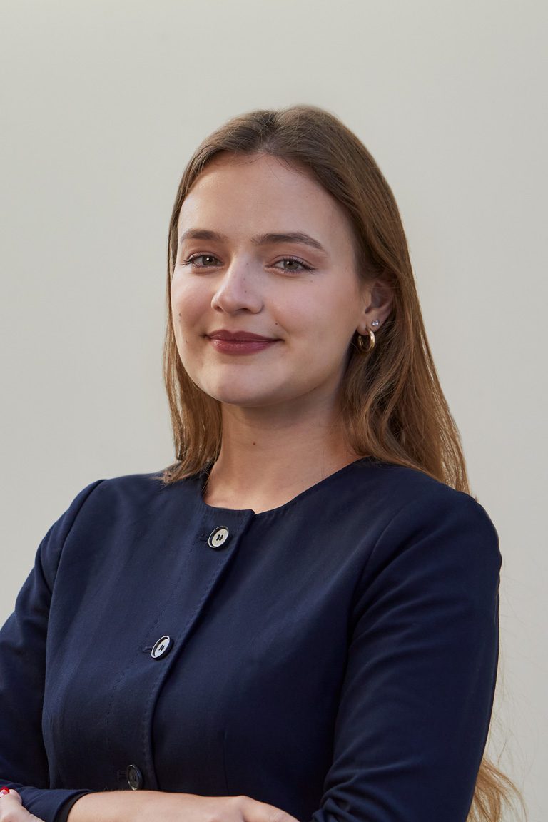Maria Clara Ribeiro Siqueira ’25 wearing a navy top with her arms crossed at the front.