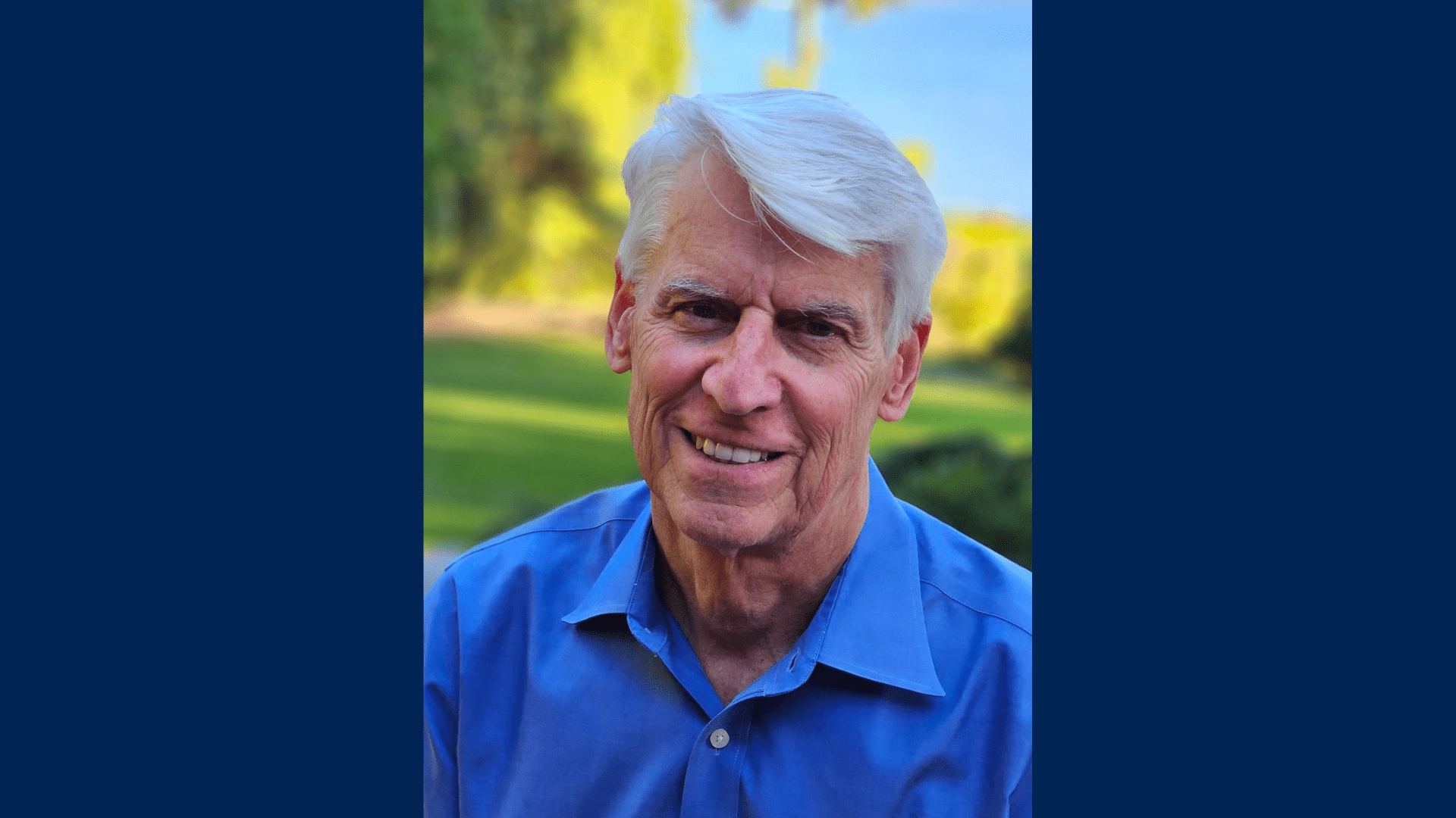 A headshot of Scott Morris posing outdoors in a blue polo shirt.