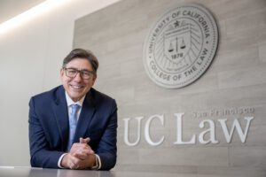 Portrait photo of David Faigman in front of a UC Law SF sign and seal.
