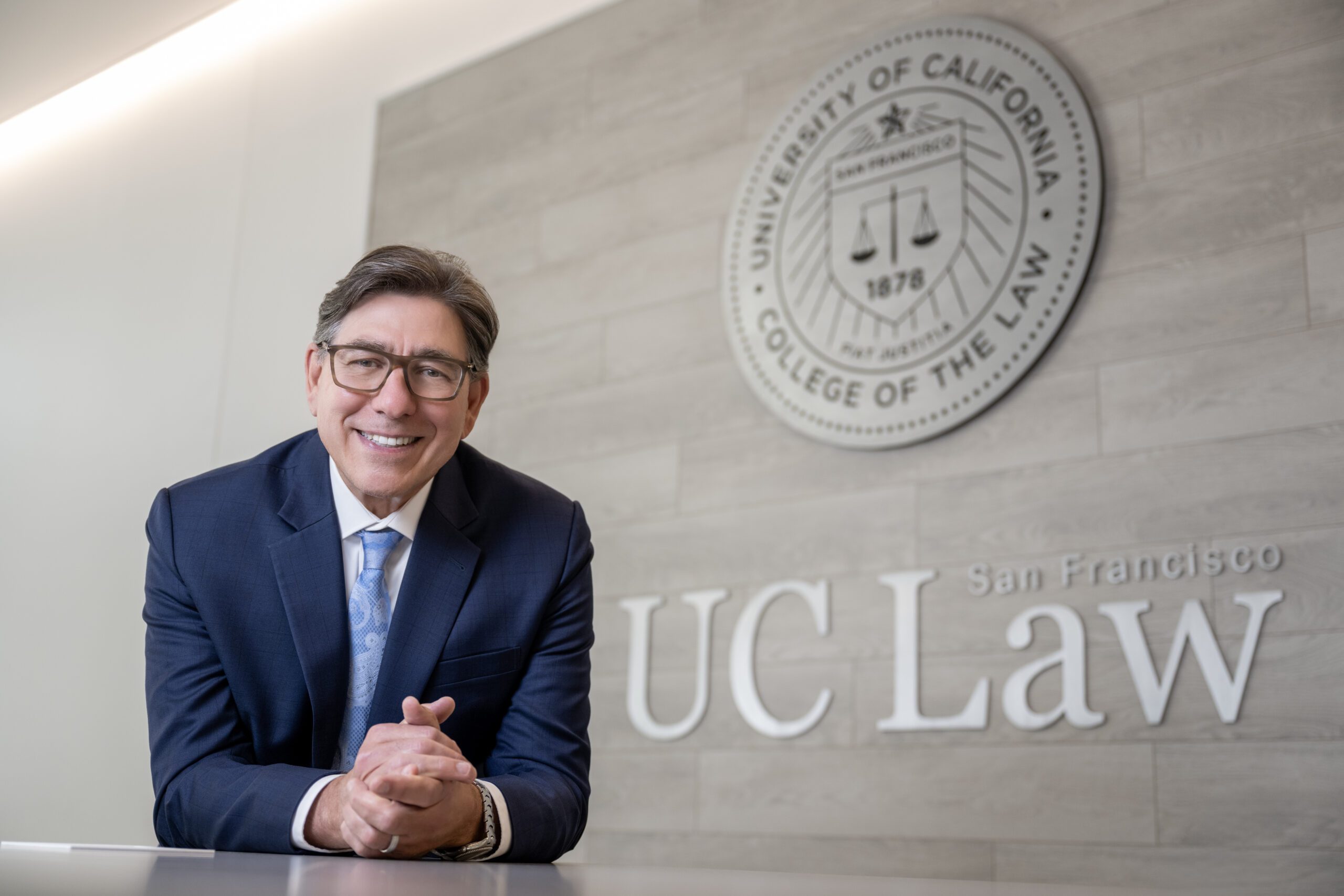 Portrait photo of David Faigman in front of a UC Law SF sign and seal.