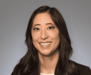 Headshot of Jenny Kwon in a black suit jacket with long dark hair.