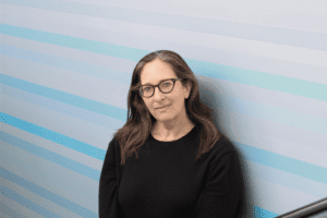 A headshot photo of Nicole Ozer wearing glasses and a dark sweater