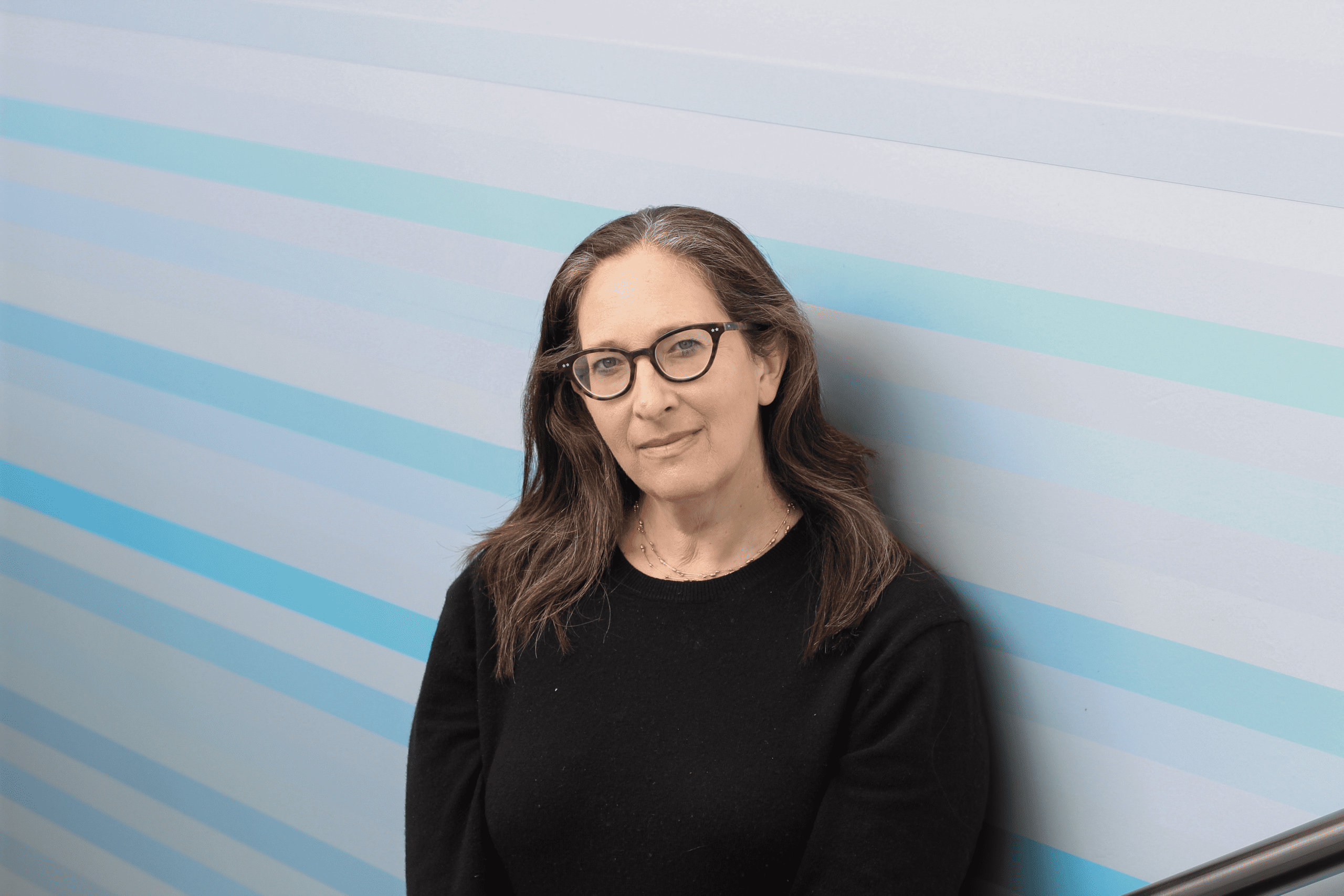 A headshot photo of Nicole Ozer wearing glasses and a dark sweater