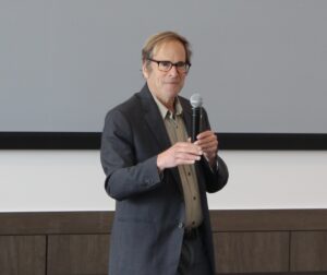 A photo of Randy Shaw speaking with a microphone.