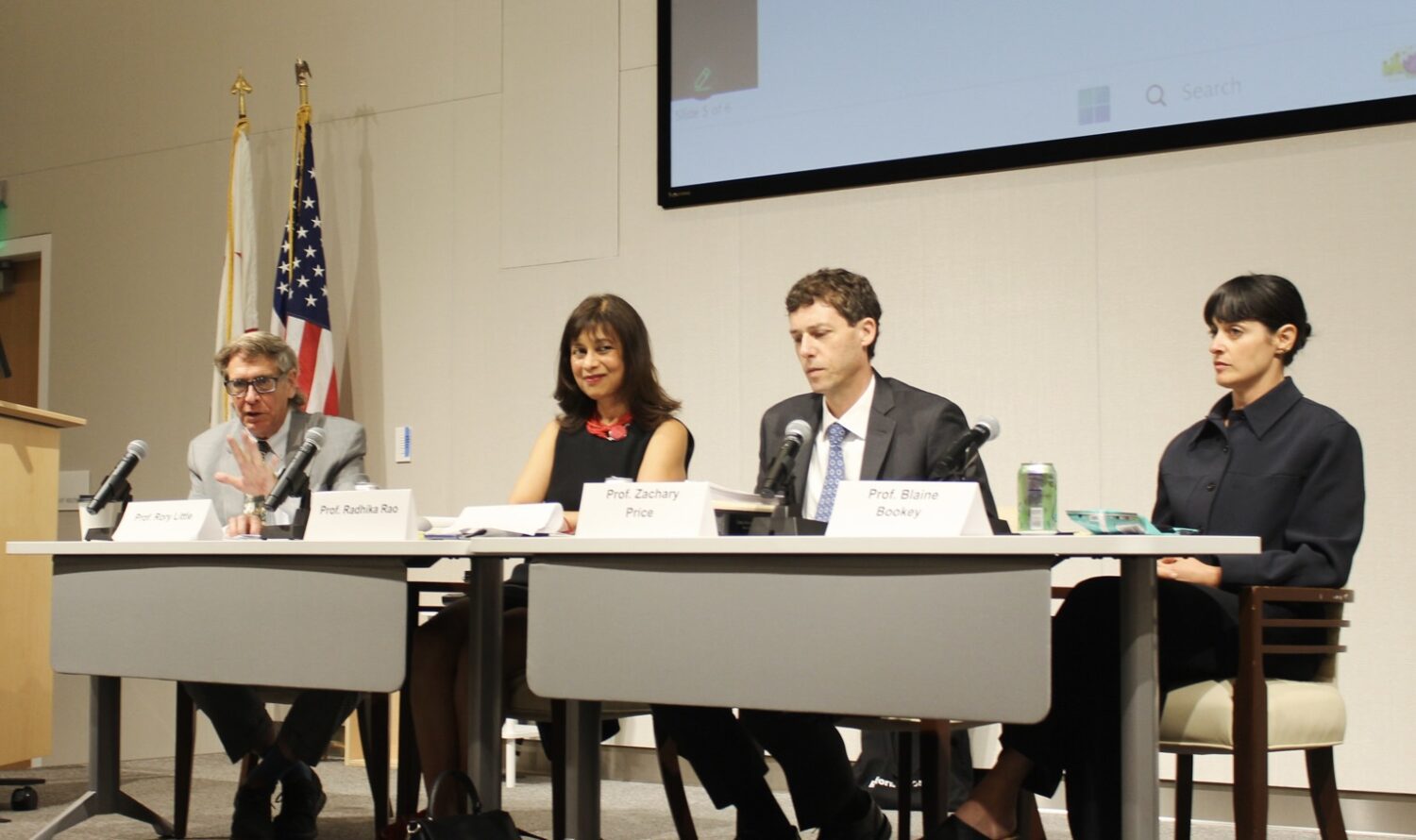 Four professors sit behind a table with microphones.