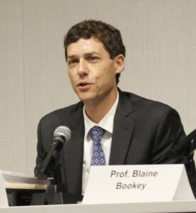 Professor Zachary Price speaks into a microphone.