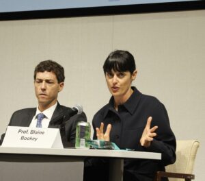 Blaine Bookey speaks with Zachary Price seated to her right.