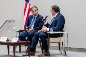Seated next to Rob Bonta, David Faigman speaks into a microphone